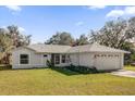 Single story home with a two car garage and well maintained lawn at 38100 Ricker Dr, Lady Lake, FL 32159