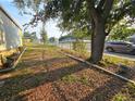 Side yard with mature trees and sparse landscaping at 6254 Balboa Dr, Orlando, FL 32808