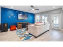 Living room with blue accent wall, comfy seating, and geometric rug at 6912 S Atlantic Ave, New Smyrna Beach, FL 32169