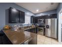 Modern kitchen with dark cabinetry, stainless steel appliances, and granite countertops at 8747 Isla Bella Dr, Orlando, FL 32818