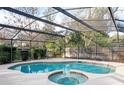 Inviting screened-in pool and spa with a wooden fence at 282 S Fox Chase Pt, Longwood, FL 32779