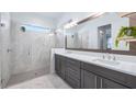 Modern bathroom with double vanity, large mirror, and walk-in shower at 15810 Shorebird Ln, Winter Garden, FL 34787