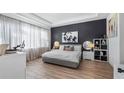 Bright bedroom with a gray platform bed and dark-accent wall at 15810 Shorebird Ln, Winter Garden, FL 34787