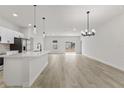 Open concept kitchen and living area with island and pendant lights at 16895 Sw 50Th Cir, Ocala, FL 34473