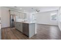 Modern kitchen with gray cabinets, island, and stainless steel appliances at 1707 Merthie Dr, Sanford, FL 32771