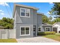 Charming two-story home showcasing a modern gray exterior with white window trim and a paved driveway at 1875 Staunton Ave, Winter Park, FL 32789