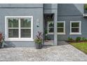 Inviting front entrance with gray siding, paver walkway, and potted plants at 1875 Staunton Ave, Winter Park, FL 32789