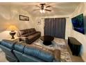 Living room with brown couches, coffee table, and large TV at 1950 Summer Club Dr # 302, Oviedo, FL 32765