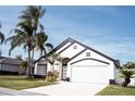 Two-story house with white exterior, black accents, and a two-car garage at 2319 Island Club Way, Orlando, FL 32822