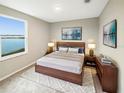 Spacious bedroom with lake view, wooden bed frame, and neutral decor at 4269 Desert Rose Ave, Kissimmee, FL 34746