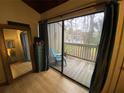 Bedroom with access to balcony featuring wood floors and view of trees at 5302 Burning Tree Dr # F-02-2, Orlando, FL 32811