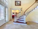 Elegant entryway with a curved staircase and stained glass door at 632 Long Lake Dr, Oviedo, FL 32765