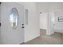 Bright entryway with white door and tiled floors, showing access to other rooms at 693 Rochester Ct, New Smyrna Beach, FL 32168