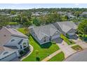 Aerial view of a well-maintained home showcasing its lawn, roof, and proximity to the water at 693 Rochester Ct, New Smyrna Beach, FL 32168