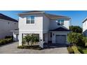 Two-story house with gray siding, covered entryway, and two-car garage at 7668 Fairfax Dr, Kissimmee, FL 34747