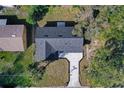 Birds eye view of the house roof and driveway surrounded by green lawns and trees at 2033 N Orange St, Mount Dora, FL 32757