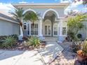Inviting front entry with decorative columns and lush landscaping at 2077 Wembley Pl, Oviedo, FL 32765