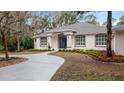 Curved driveway leading to a charming house with blue front door and well-manicured landscaping at 2397 River Tree Cir, Sanford, FL 32771
