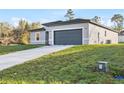 A modern single-story house shows off a new concrete driveway and gray garage door at 265 Marion Oaks Mnr, Ocala, FL 34473