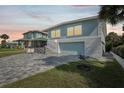 Newly renovated home with gray paver driveway and walkway at dusk at 447 Seaview Ave, Daytona Beach, FL 32118