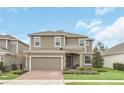 Two-story home with neutral siding, brick paver driveway, and landscaping at 936 Jetway Street, Orange City, FL 32763