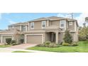 Two-story home with neutral siding, brick paver driveway, and landscaping at 936 Jetway Street, Orange City, FL 32763