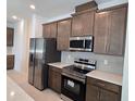 Stainless steel appliances and dark brown cabinets in kitchen at 1200 Happy Forest Loop, Deland, FL 32720