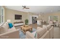 Open living area with beige sofas, a coffee table, and a view into the kitchen at 14 Fisher Loop Pass, Ocklawaha, FL 32179