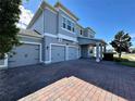 Two-story house with three-car garage and brick driveway at 16750 Toccoa Row, Winter Garden, FL 34787