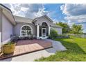 Home featuring a tiled front patio and a well-maintained lawn at 17901 Coralwood Ln, Groveland, FL 34736