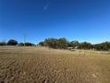 Open pasture with trees and a wire fence at 17901 Coralwood Ln, Groveland, FL 34736