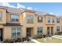 Tan two-story townhome with brown door and landscaping at 2182 Fleming Mist Pl, Kissimmee, FL 34747