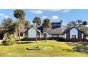 House exterior showcasing a two-story home with a spacious lawn and palm trees at 2305 Leeward Cv, Kissimmee, FL 34746