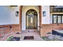 Welcoming front entry featuring a decorative door framed by brick columns and stylish outdoor lighting fixtures at 2305 Leeward Cv, Kissimmee, FL 34746