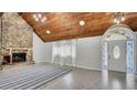 Inviting living room features a stone fireplace, wood ceiling, and arched glass door at 2305 Leeward Cv, Kissimmee, FL 34746