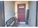 Welcoming front entry with a burgundy door, bench, and decorative welcome sign at 2518 Hayden Valley St, Apopka, FL 32703