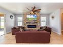 Cozy living room features a stone accent wall with fireplace and neutral furniture at 2570 Marshfield Preserve Way, Kissimmee, FL 34746