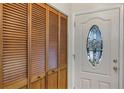 Interior entryway showcasing a white door with a stained-glass window and wooden closet at 3002 Clubview Dr, Orlando, FL 32822