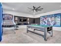 Spacious game room with basketball hoop, pool table, foosball, and superhero wall decor at 3012 Penelope Loop, Kissimmee, FL 34746