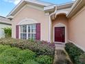 Front entry with burgundy door and well-maintained landscaping at 337 Fern Lake Dr, Orlando, FL 32825