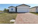 Charming single-story home featuring a brick driveway, manicured lawn, and a two-car garage at 4537 Sidesaddle Trl, St Cloud, FL 34772