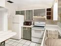 Galley-style kitchen with grey cabinets and white appliances at 5240 N Powers Dr, Orlando, FL 32818