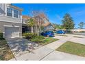 Townhome with gray exterior, two-car garage, and nicely landscaped area at 622 Glastonbury Dr, Orlando, FL 32825