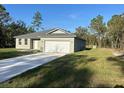 New construction home with a driveway and grassy yard at 8944 Sw 128Th Pl, Ocala, FL 34473