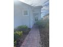 Brick walkway leading to the house entrance, bordered by lush greenery at 922 Umbria Dr, Poinciana, FL 34759