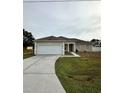 Tan house with white garage door and columns at 975 Gascony Ct, Kissimmee, FL 34759