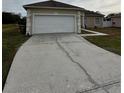 White garage door with cracked driveway at 975 Gascony Ct, Kissimmee, FL 34759