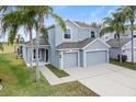 Two-story house with gray siding, three-car garage, and palm trees at 9856 Heron Pointe Dr, Orlando, FL 32832