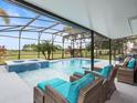 Inviting pool and spa with screened enclosure and patio furniture at 9856 Heron Pointe Dr, Orlando, FL 32832