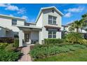 Inviting home highlighting well-maintained landscaping, a paved walkway, and a cozy front porch seating area at 11526 Comic Aly, Orlando, FL 32832